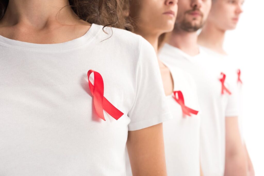 cropped-image-of-people-standing-with-red-ribbons